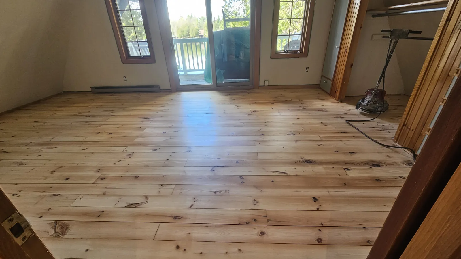Wide plank floor freshly sanded back to bare wood, ready for finishing